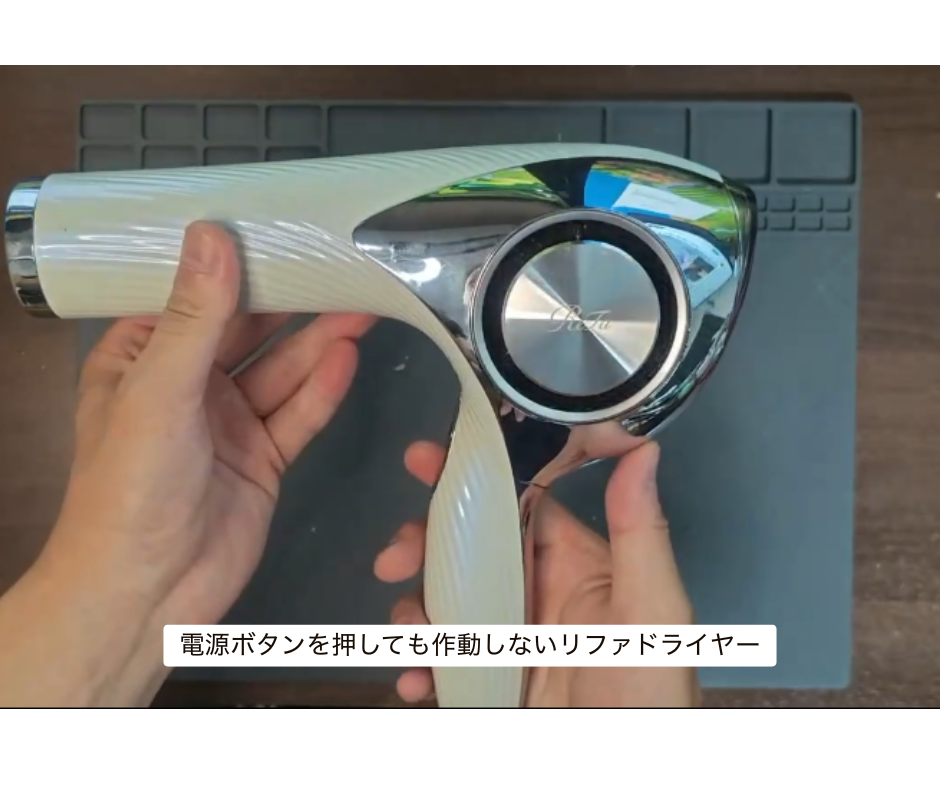電源ボタンを押しても動かないリファドライヤーの故障状態を確認する様子